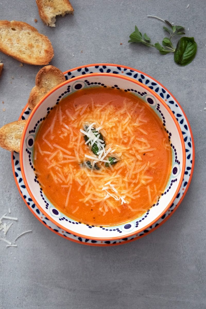 orange soup on white and blue ceramic bowl
