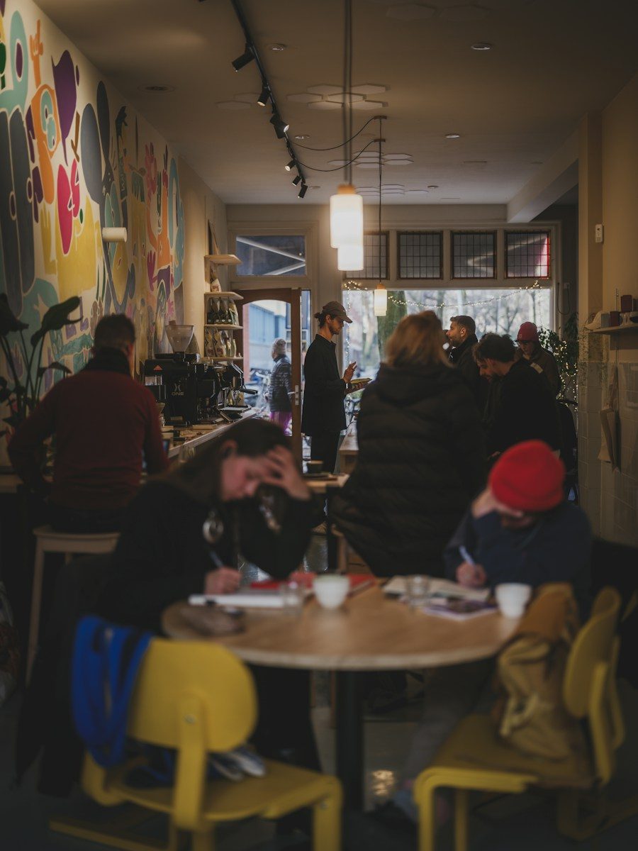 People gathered inside a cafe with colorful wall art